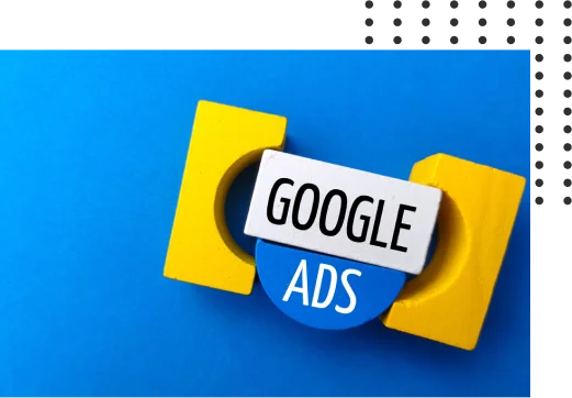 A block with "GOOGLE" on a white background and "ADS" on a blue background, framed by two yellow shapes, on a blue surface.