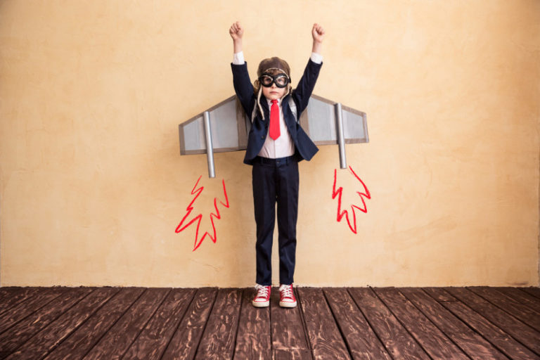 Finding Your Dream Job can be a lot easier with a personal website to showcase your skills. Little kid in a suit and tie with airplane wings on and reaching to the sky.