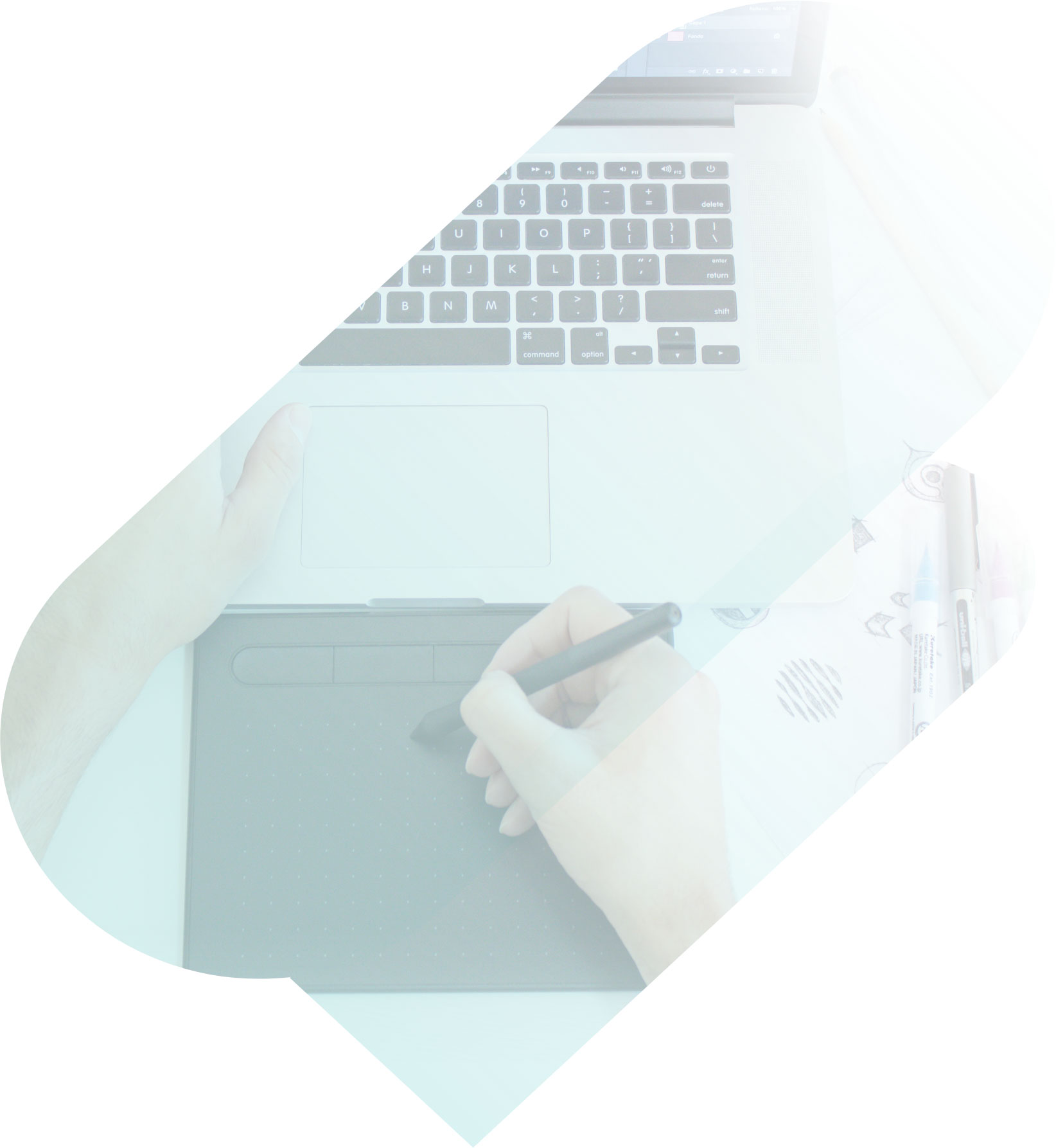 A person writing on a digital writing pad connected to a laptop