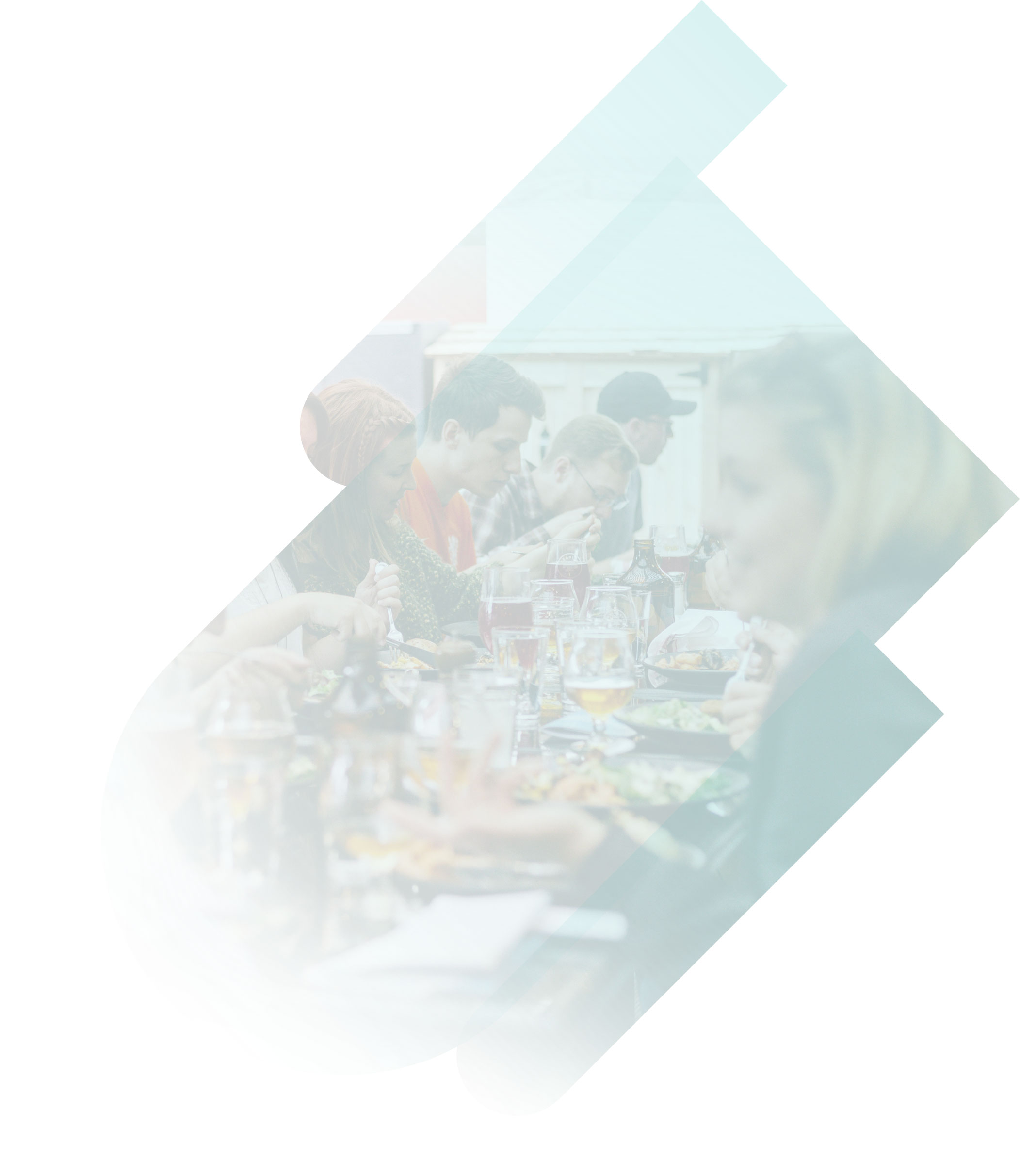 People sitting around a long table full of food and drinks