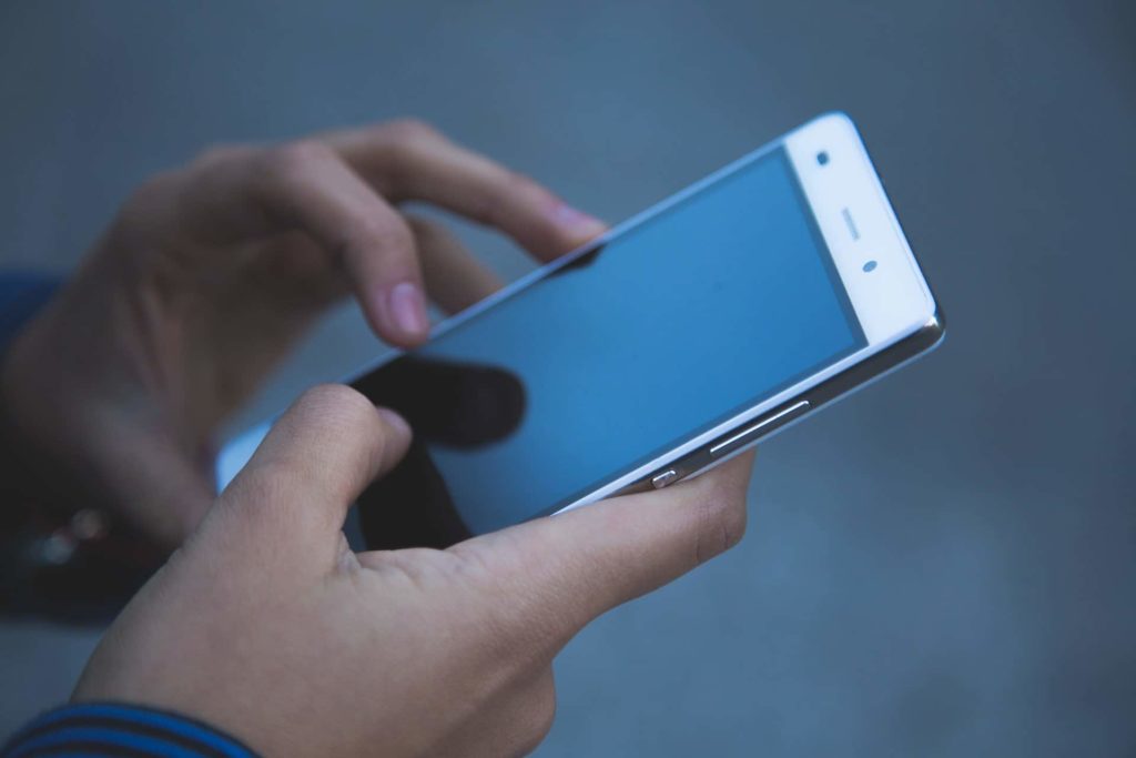 A person holding a cellphone with both of his hands