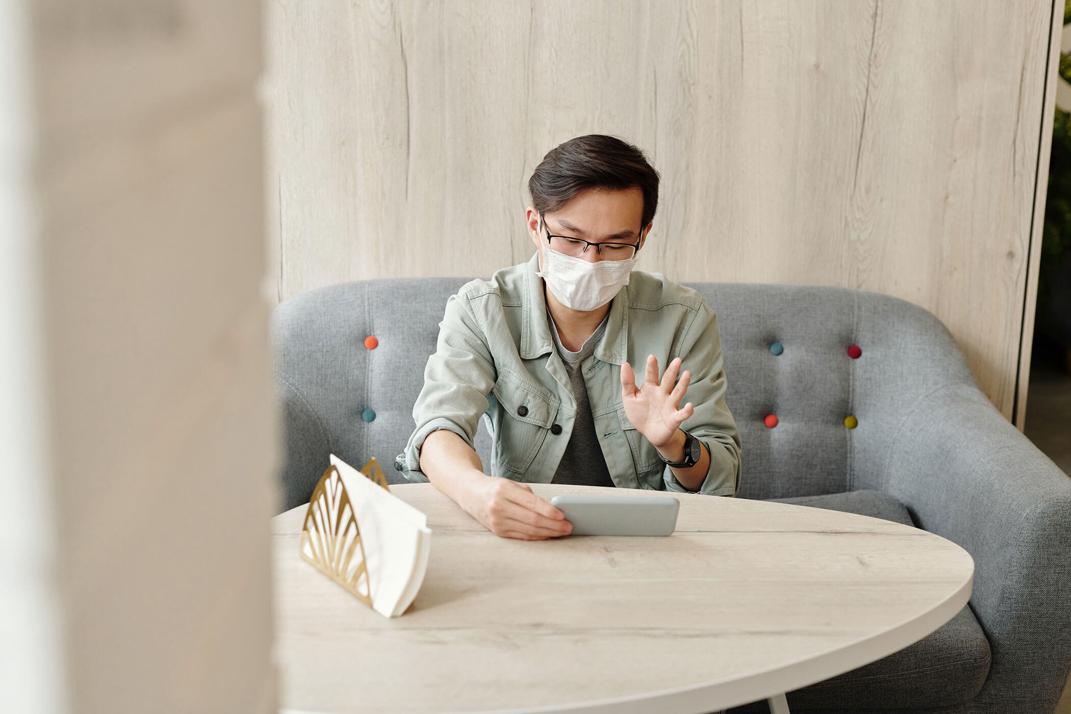 Man wearing a face mask having a video call Man wearing a face mask having a video call