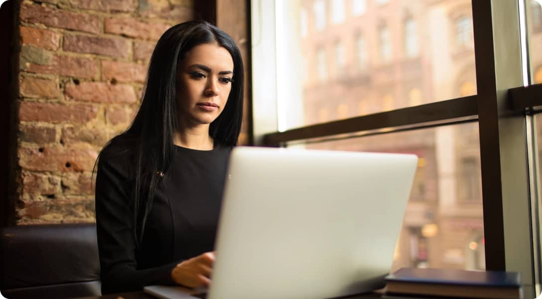 Serious confident business woman having online training course on laptop computer