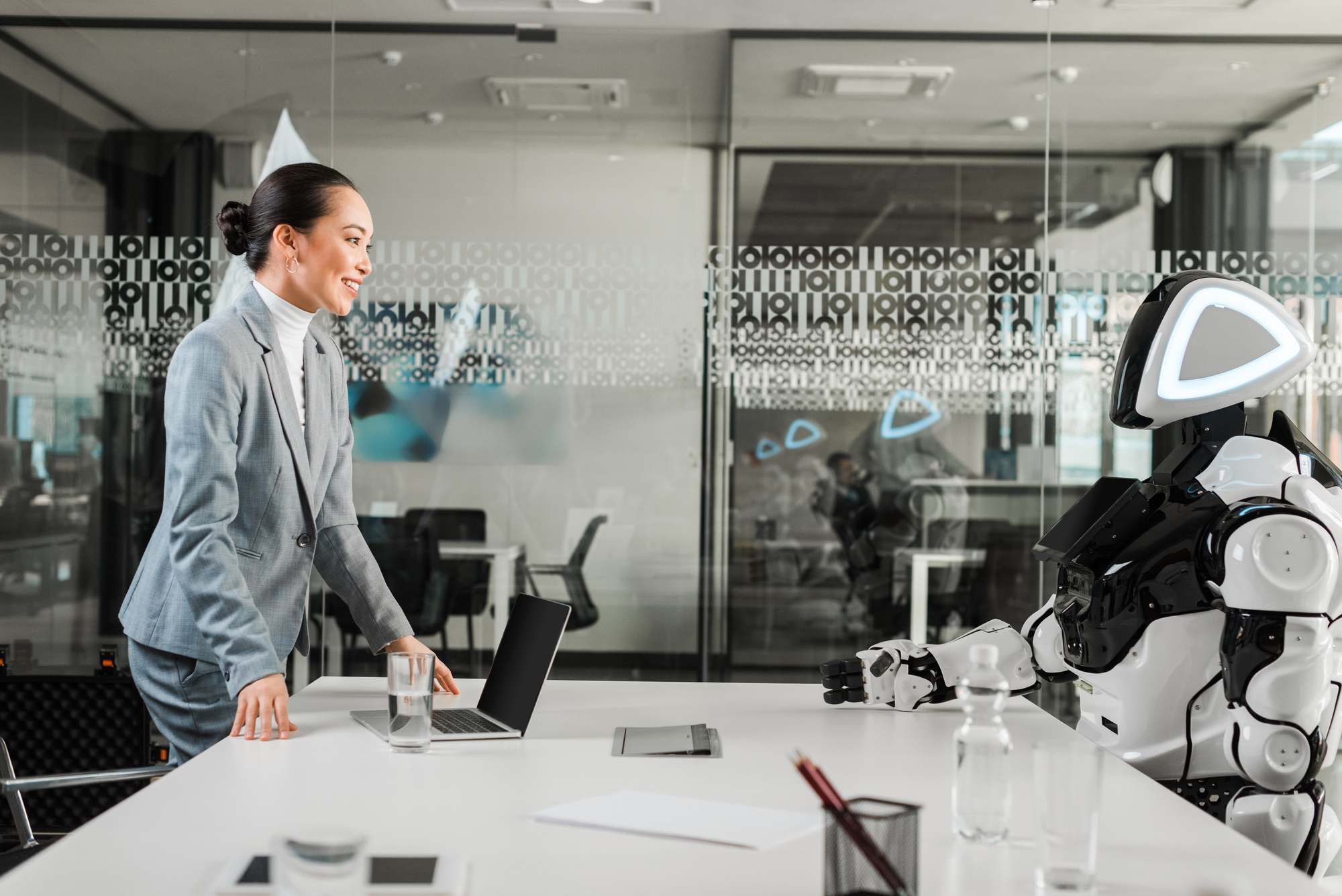 human writer talking to an AI robot inside a meeting room